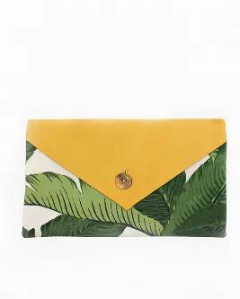Buttery soft Haitian leather from a tannery in Port Au Prince is combined with tropical fabric accented with swaying palm tree branches. This clutch is the perfect size for your essentials and is lined in an earthy tan. Toss this in a tote or carry alone for a tropical summer feeling! <br> Details: button closure <br> Size: 5.5" x 10" <br> Colors: green, yellow, ivory <br> Handmade by Vi Bella artisans