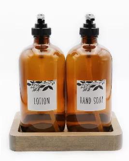 <p>The perfect decorative, yet functional, accent to every sink!  2 amber colored glass bottles with labels (one "Lotion", one "Hand Soap") and black pumps.  These bottles fit perfectly into the beautiful wood tray made by our Haitian artisan partner.  </p>
<p>Details: wood tray 7" x 4 1/2" x 1". <br></p>