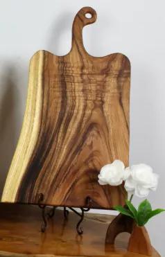 This live edge board is hand crafted from East Indian Walnut. Each piece is hand selected for their grain and fit. Our extra large handled boards are 24" long (including handle) x 10-14" wide x 1" thick. They are perfect for serving cheese boards or charcuterie for larger groups, prepping your favorite family meal, or setting out appetizers when hosting guests.