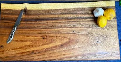 This live edge board is hand crafted from East Indian Walnut. Each piece is hand selected for their grain and fit. Our extra large live edge square boards are 24" long x 12" wide x 1" thick. Each board has convenient finger reliefs on the bottom, making them easy to pick up and move. Utilized for chopping or serving, these boards can be fully reversible, making them ideal for kitchens of any kind.