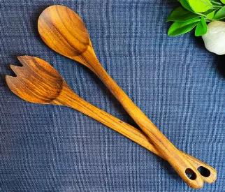 This rustic hand carved two piece teak salad serving set is a beautiful and practical addition to any kitchen. Each utensil set is hand carved from beautiful and durable Teak wood, giving it a rustic nice feel in your hand. Each set includes a medium spoon and salad spork. Each utensil is 13" long and has a convenient hanging hole so they can be on display and within easy reach in your kitchen. The utensils are sealed with food-safe mineral oil for a beautiful finish.