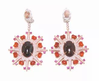 <p>Behold the beauty and splendor of this sparkling swirl design from Canari Jewels ! Simulated Ruby & White Diamonds surround and draw the eye in to each oval shape red mohcony and red agate gem stones . They're crafted of polished sterling silver and secure to the ears via omega backs.</p><div><h3>Drop Earring Details</h3><ul><li>Metal: 925 Sterling Silver Rose Gold Embraced</li><li>Stone Information:</li><li>Natural Red Agate: 16 Oval Shape Hand Cut 4 x 6 mm Each Stone</li><li>Natural Mahcony