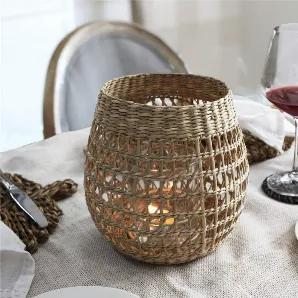 Our wicker candle holder is woven by the skillful hands of artisans in Vietnam. It is made to details, making it a flawless rustic d?cor accent. The strong inner glass cup protects the candle inside and reflect candle lights while the unique patterns of the outer holder gives outstanding lighting effects to your space..<br>This seagarass lantern is loved on wedding or party table, it makes a simple yet outstanding dining centerpiece. It is also ideal for daily use at home, on your tea table, lat