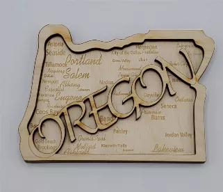 2D Home Magnet - Representing the great state of Oregon.  Richly detailed with many of Oregon's popular cities and towns engraved on the back layer.  A second layer is applied to the top with the outline word OREGON cut via a precision laser process.  3.76" wide