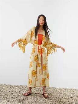 <p>Fringed long kimono with short sleeves. Tied waist.</p>
<p>Bohemian: Traditional silhouettes with sun scorched hues from the past warm our hearts in the present. Forms that represent power and femininity meet warm colors. Function-forward dresses with an elegant flair take a front seat in Spring / Summer collections as complementing kimonos offer an update to your personal style.</p>
<p>50% Rayon 45% Viscose 5% Silk</p>
<p>Hand Wash Cold; Do Not Tumble Dry; Iron Low; Dry Clean</p>
<p>Do Not B