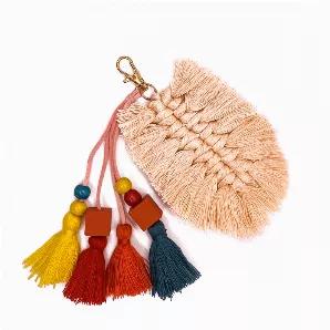 This tassel uses cotton thread that is knotted in the shape of a leaf. Suede roping with beads and smaller tassels hang down to complete the look.