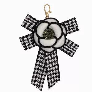 This tassel has a black and white checkered bow with a white flower outlined in black with rhinestones. Add a piece of sophistication to your bag!