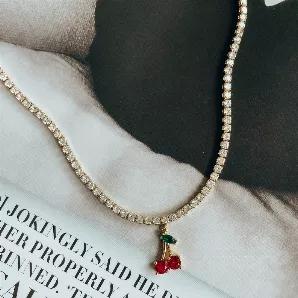 <p>Reviving Y2K vibes, this beautiful tennis necklace features a cherry pendant, perfect to liven up any outfit! Dress it up for night time with an LBD or down for a casual day look with jeans and a crop top. Matching piece to our <a href="https://heymaeve.com/products/cherry-ray-anklet">Cherry Ray Anklet</a> and <a href="https://heymaeve.com/products/cherry-ray-studs">Cherry Ray Studs.</a></p><p>Material: </p><p>18K Gold Plated Brass</p><p>16inch + 5cm extender</p><p>Cubic Zirconia </p><p>Water
