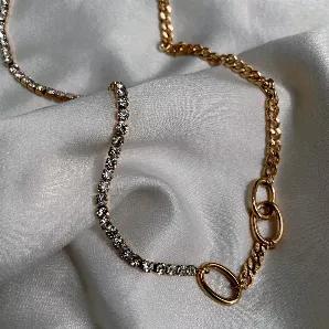 <p>This gorgeous necklace features 2 chains, a cubic zirconia tennis necklace chain and a gold cuban chain with ring links. Wear along for an elegant minimalistic look, or layer with our other chains for more oomph. </p><p>Material:</p><p>18K Gold Plated Stainless Steel</p><p>Length: 45cm + 5cm extender</p><p>Water Resistant, Tarnish Resistant, Nickel Free</p>