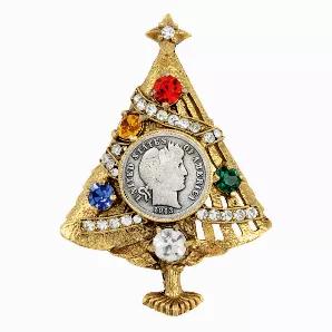Inspired by the 1950 and 60s Hollycraft Christmas Tree Pins, the Silver Barber Dime Christmas Tree Brooch offers a historical addition of American pride to the holiday wearer. The gold tone Christmas tree is decorated with clear glass rhinestone garland and multi-colored glass ornaments, in the center is a genuine .900 silver Barber Dime. The Barber Dime was minted from 1892 to 1916 and features the profile of lady liberty with a wreath made from an olive branch in her hair symbolizing peace. Th