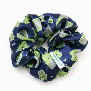 Satin scrunchie featuring Frankenbear on a navy blue background with white lightning bolts.<br>The silky satin fabric makes for a snag-free hair experience. Wrap around a ponytail or bun for a fun pop of Halloween season spirit.<br>Inner elastic stretches from approximately 2" to 7" wide. The whole scrunchie measures approximately 5" in diameter when unstretched.