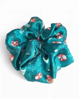 Satin scrunchie featuring a fun pattern of woodland animals (fox, badger raccoon, wolf, owl) and forest doodles on a teal background.<br>The silky satin fabric makes for a snag-free hair experience. Wrap around a ponytail or bun for a fun pop of bookish spirit.<br>Inner elastic stretches from approximately 2" to 7" wide. The whole scrunchie measures approximately 5" in diameter when unstretched.