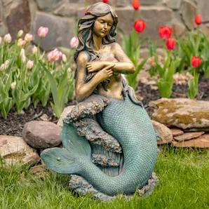Bring the fantasy home with the Zaer Ltd. Mermaid Garden Statues. Crafted from quality magnesium, our mermaid statues features complex textures and unique hand painted finishes making each piece one of a kind. The muted teal green contrasts with the antique metallic bronze creating a dynamic structure that is guaranteed to impress. Dezlynn features long flowing hair that gently covers her chest as she sits atop a rock while waves crash around her. <br><br>- Indoor/Outdoor<br>- 100% quality magne