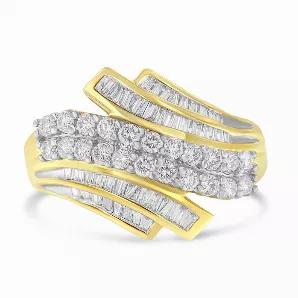 Fashioned in 10k yellow gold, this ring showcases 1ct TDW of diamonds. The ring band is inlaid with glimmering round cut diamonds and creates a soft wave at the front. Yellow gold ribbons emerge from the ring band and flow over the top and bottom of the diamond inlaid band creating a bypass design. Baguette cut diamonds stud the bypassing bands and add extra sparkle to the design.