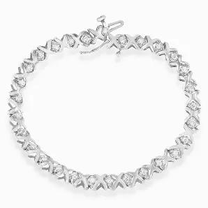 Stunning 10K white gold diamond tennis bracelet that embellishes the wrist with 1ct of sparkling round cut diamonds prong set between gold x shaped links.