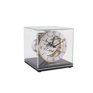The minimalistic cubic form of this table clock makes it the perfect centerpiece from any angle. The mechanical movement features Westminster chimes on bells, automatic night shut off and a silencing lever. The best part is that all of it is visible through the glass dome.
