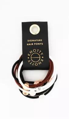 Set of 10 luxury hair elastics packaged on a vegan leather loop with gold metal grommet accent. Gold, rose gold, & rhodium gleaming metal signature accents mixed with playful colors makes the Signature Pony a classic Knotty favorite. Can be worn as a hair pony or a bracelet!