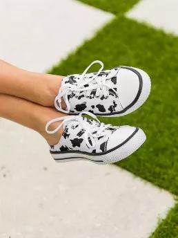 Cool canvas sneakers featuring an open back and adjustable laces. Open back makes this slip- sneaker a must have. Cow print in traditional black and white. Medium width. True to size.