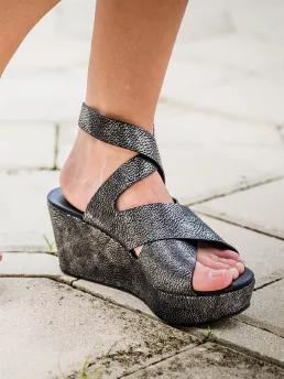 Pewter wedges with a hint of black. Its the perfect combo to add flair to your outfit. These wedges are comfortable and lightweight. These beautiful wedges also feature a unique strappy design with an ankle strap has a 2.75" heel and a 1" platform.  Lightly padded insole, and adjustable buckle. True to size.