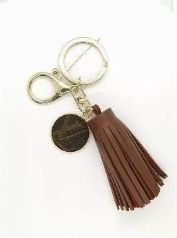 Tan vegan leather tassel keychain with Louis Vuitton Charm. Charm repurposed from LV Speedy 35 FH1912.