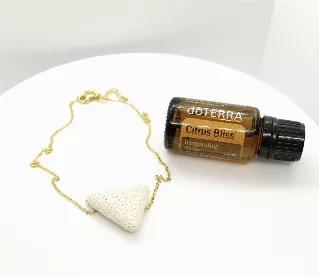 Necklace and essential oil - SET.\n\nWhite triangle cut lava bead pendant on gold plated stainless steel chain with lobster clasp closure. Necklace has adjustable sizing loops.\n\nAlso included - one bottle of doTerra Citrus Bliss essential oil blend.\n\nCitrus Bliss Invigorating Blend merges the benefits of citrus essential oils, expertly combining the powerful essences of Wild Orange, Lemon, Grapefruit, Mandarin, Bergamot, Tangerine, and Clementine with a hint of Vanilla Absolute to form this 