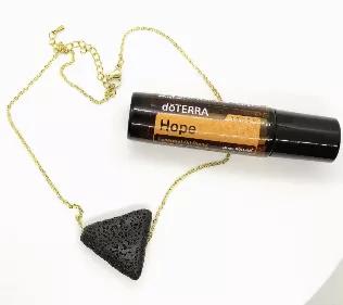 Necklace and essential oil - SET.\n\nBlack triangle cut lava bead pendant on gold plated stainless steel chain with lobster clasp closure. Necklace has adjustable sizing loops.\n\nAlso included - one bottle of doTerra Hope essential oil blend.\n\ndoTERRA Hope Touch is a distinct essential oil blend combining the fresh scent of Bergamot with Ylang Ylang and Frankincense, then sweetened slightly with the warming aroma of Vanilla Bean Absolute. doTERRA Hope Touch can be applied to the neck, wrists,