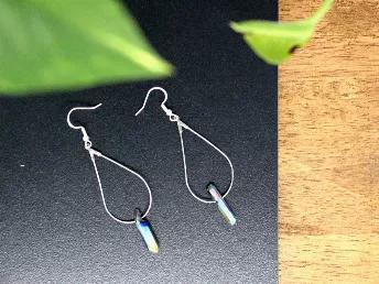 These delicate silver earrings are hand wrapped with a stunning titanium quartz crystal. <br>

Quartz treated with vaporized titanium. Provides sustainable energy + helps elevate the mood. Increases focus + confidence while expanding awareness. 
